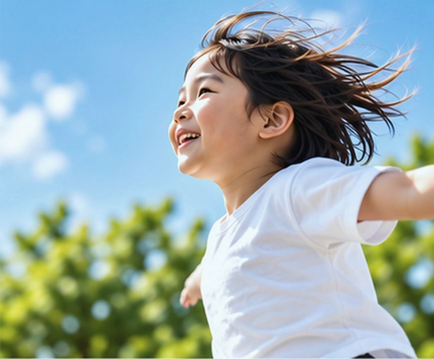 青空の下で笑顔で走る子ども